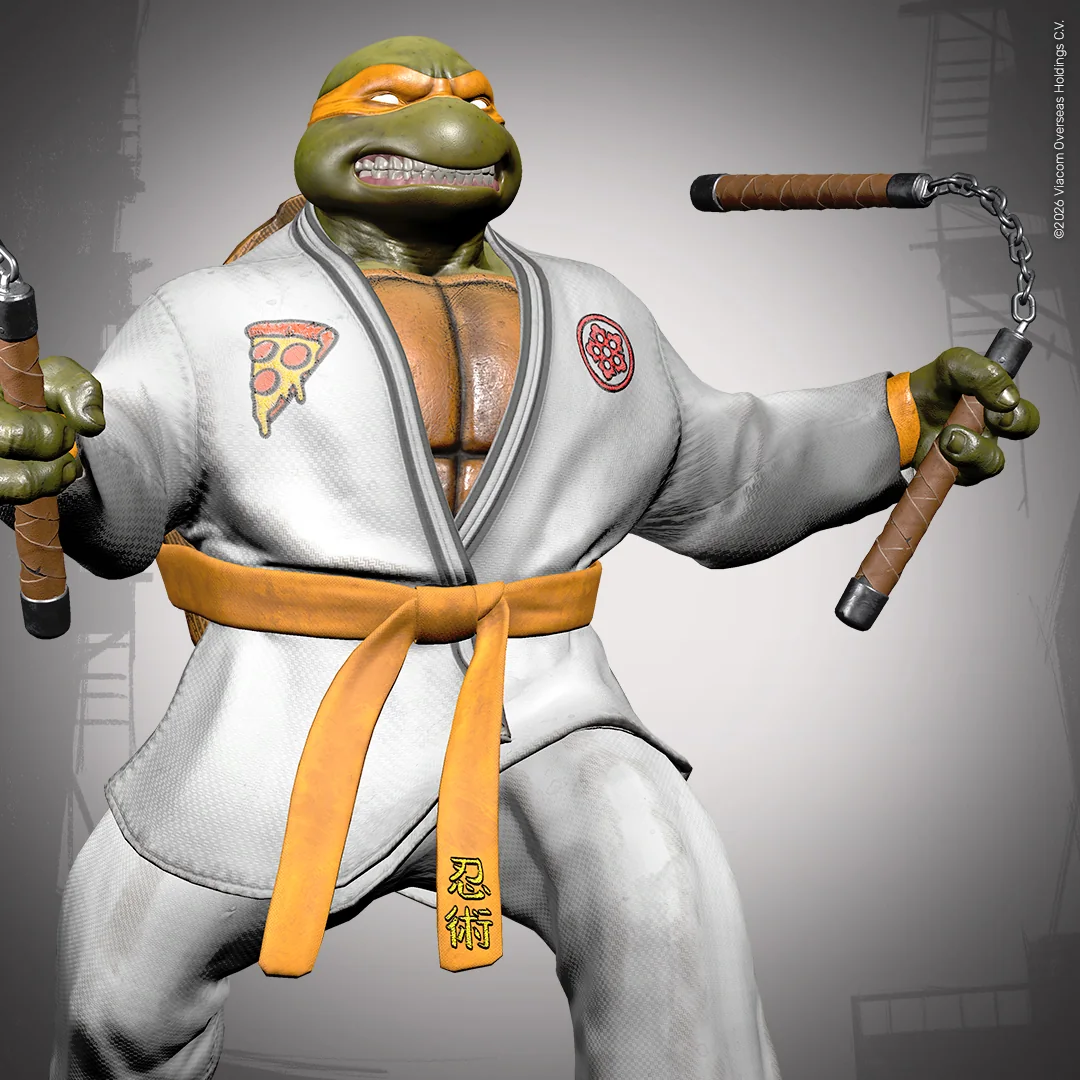 Michelangelo trägt einen weißen Dojo-Gi mit orangefarbenem Gürtel und hält seine beiden Nunchaku kampfbereit.